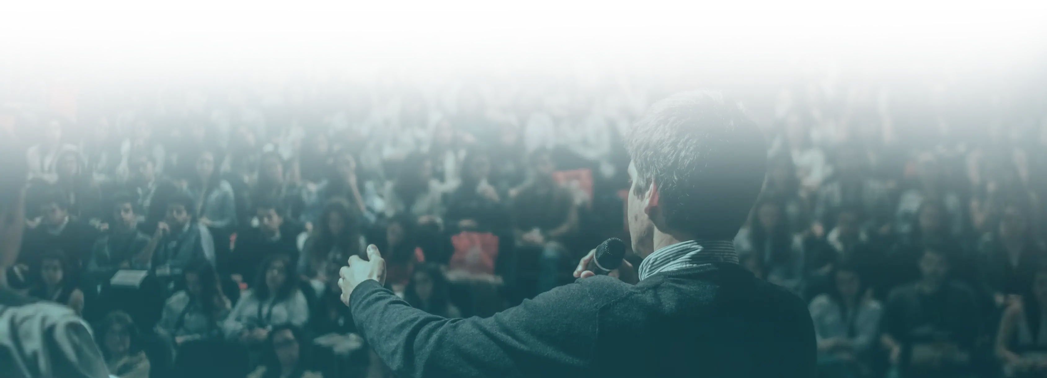 View over the shoulder of a lecturer onto a lecture hall full of students.